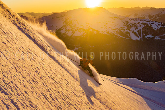 Skier in powder snow at sunset